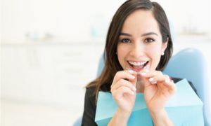 The woman fits her aligner at the dental office.